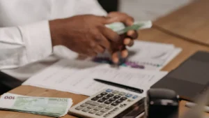 Modelo 720: billetes de euro, calculadora y documentos fiscales sobre una mesa