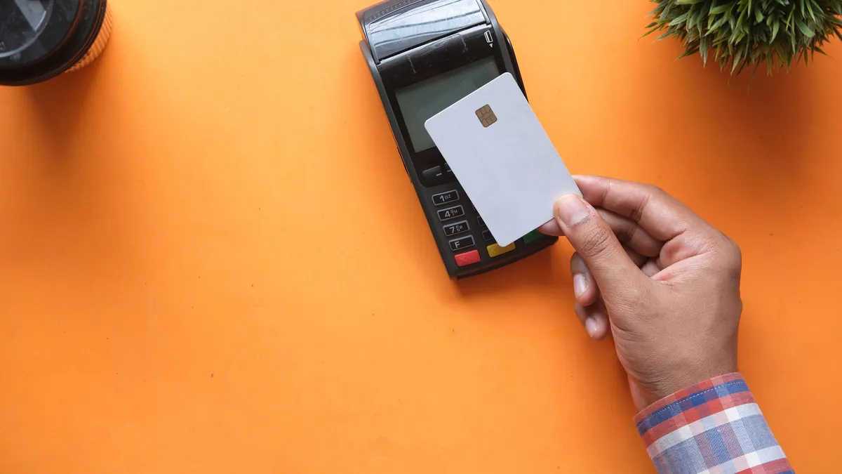 N26 vs Revolut: mano pagando con una tarjeta sin marca en un datáfono
