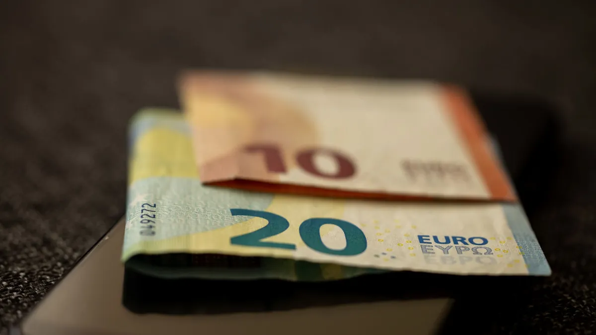 Tarjetas prepago: billetes de 10 y 20 euros sobre un móvil, como una recarga de saldo