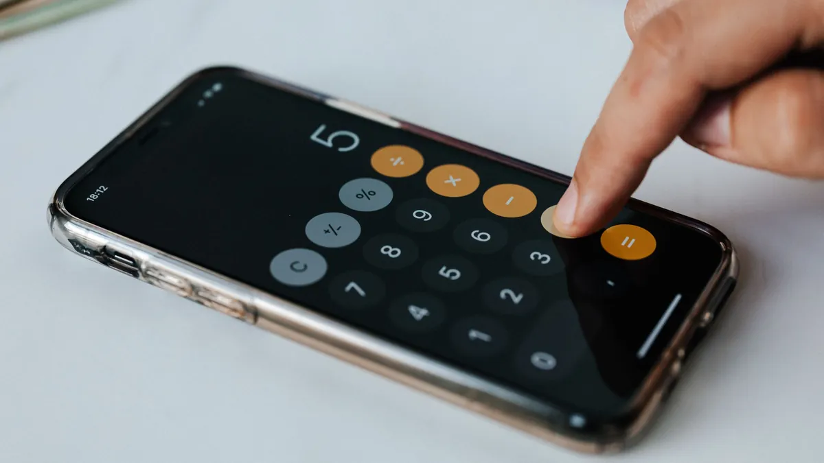 Apps con coaching financiero: persona calculando en el móvil cuánto puede ahorrar cada mes