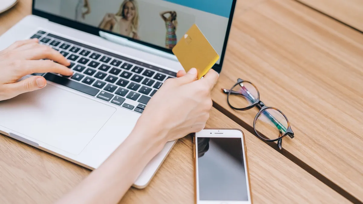 Apps de cashback: persona pagando una compra online con tarjeta desde el portátil