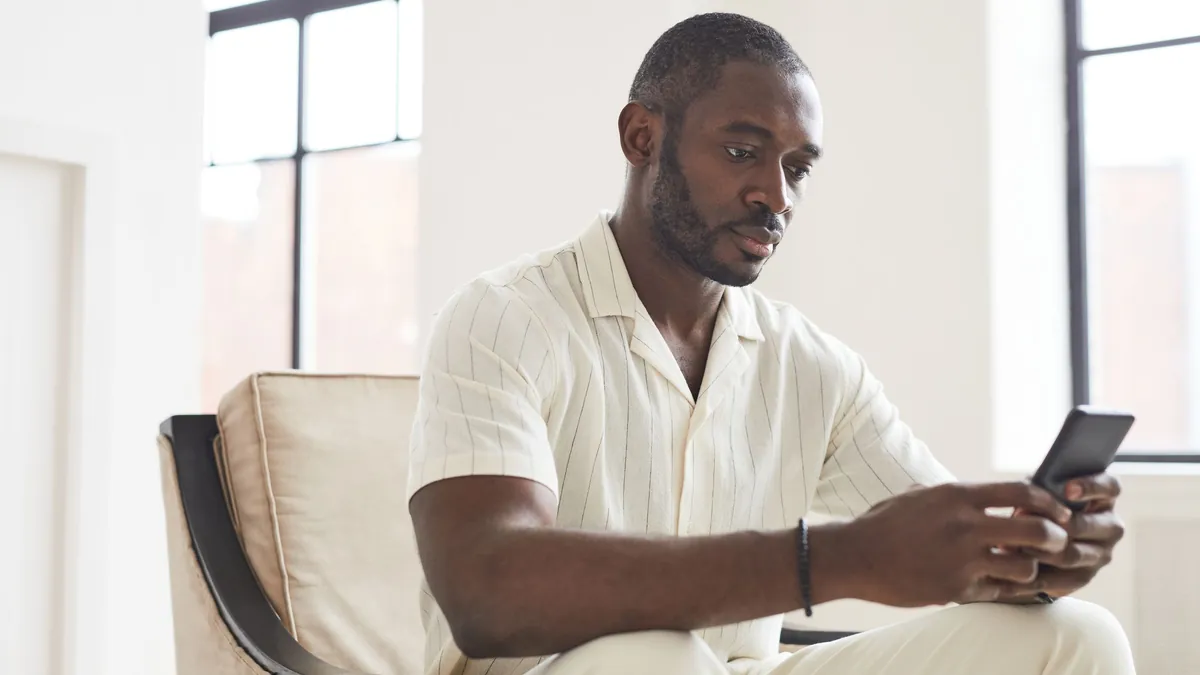 Hombre consultando los movimientos de su cuenta con IBAN español en el móvil