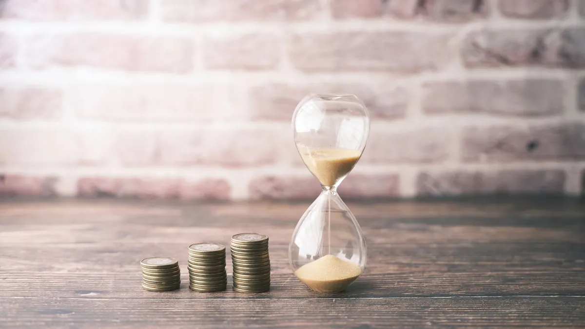 Cuenta remunerada o depósito: reloj de arena junto a tres montones de monedas que representan el plazo del ahorro