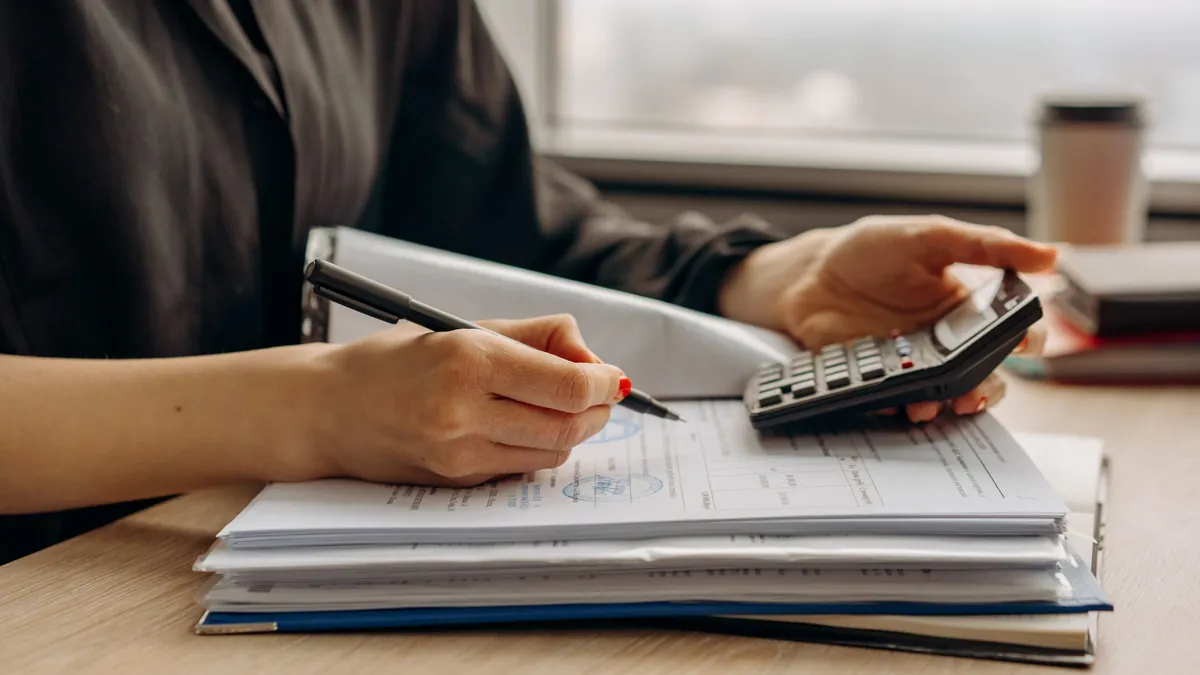 Embargo de cuenta bancaria: persona calculando con calculadora la parte inembargable de su nómina