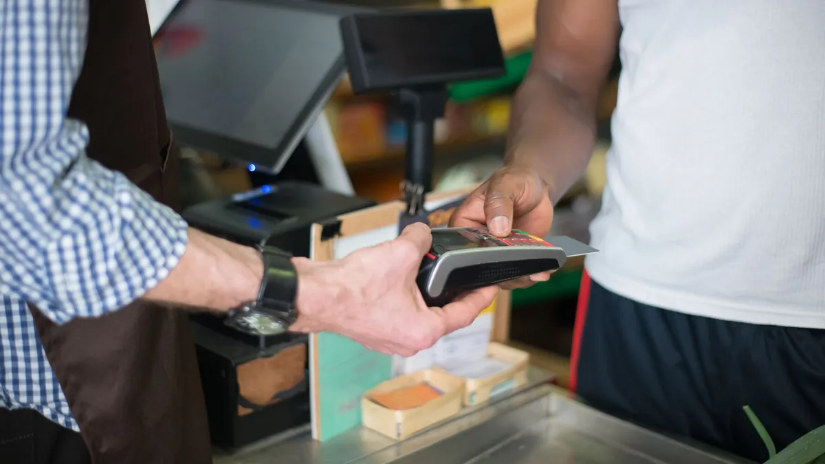 Tarjetas para viajar sin comisiones: pago con tarjeta en un datáfono de una tienda