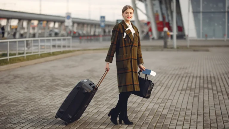 Tarjetas para viajar sin comisiones: viajera con maleta y pasaporte saliendo del aeropuerto