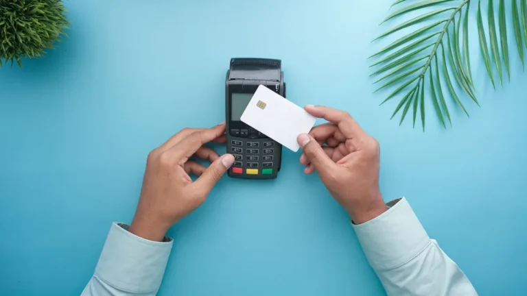 Tarjetas y pagos: manos acercando una tarjeta sin marca a un datáfono